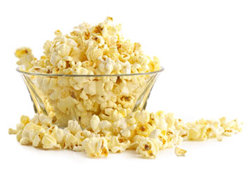 freshly popped popcorn in a clear glass bowl