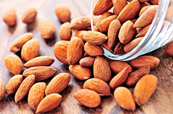 shelled almonds spilled out of a clear glass bowl