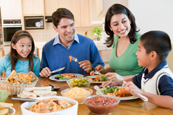 A family of four enjoying a meal together